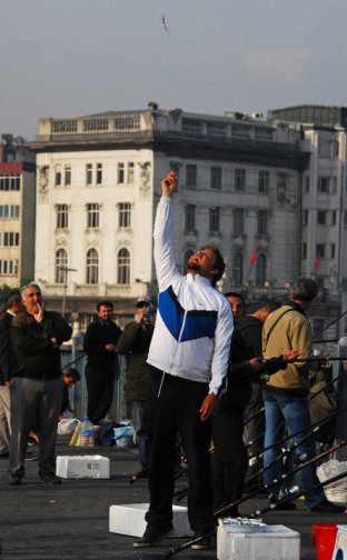 Istanbul is full of interesting characters - many of them can be found on Galata Bridge. A fisherman tosses fish in the air for the sport of seagulls. © Desiree Koh